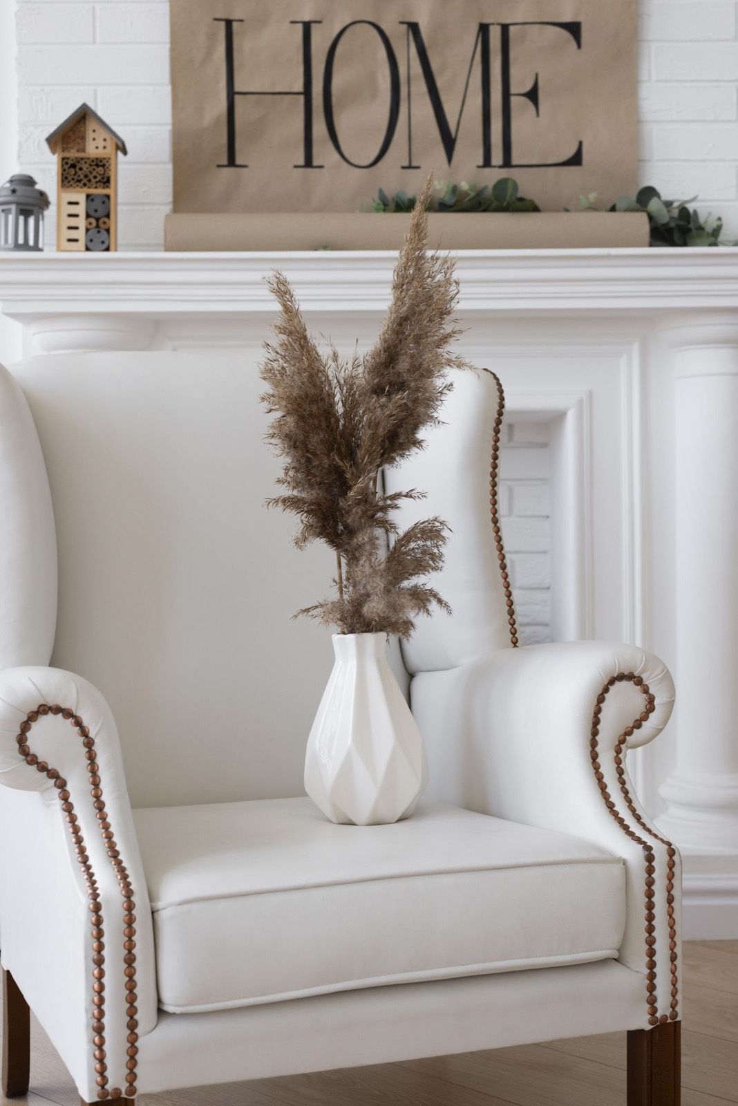 A white armchair beside a vase of dried pampas grass in the Cherry Creek office