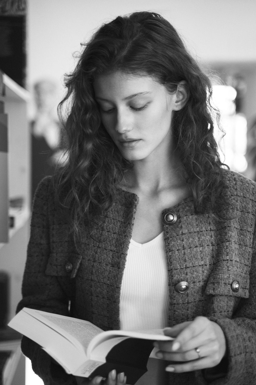 A woman with curly hair reading a book
